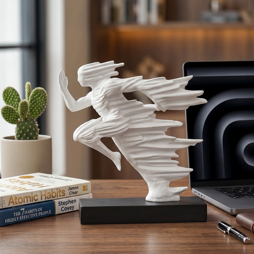 Becoming Flow white abstract running sculpture in a curated modern home office setup. Handcrafted minimalist cast stone resin art displayed on a walnut desk with a laptop, books, and natural lighting.