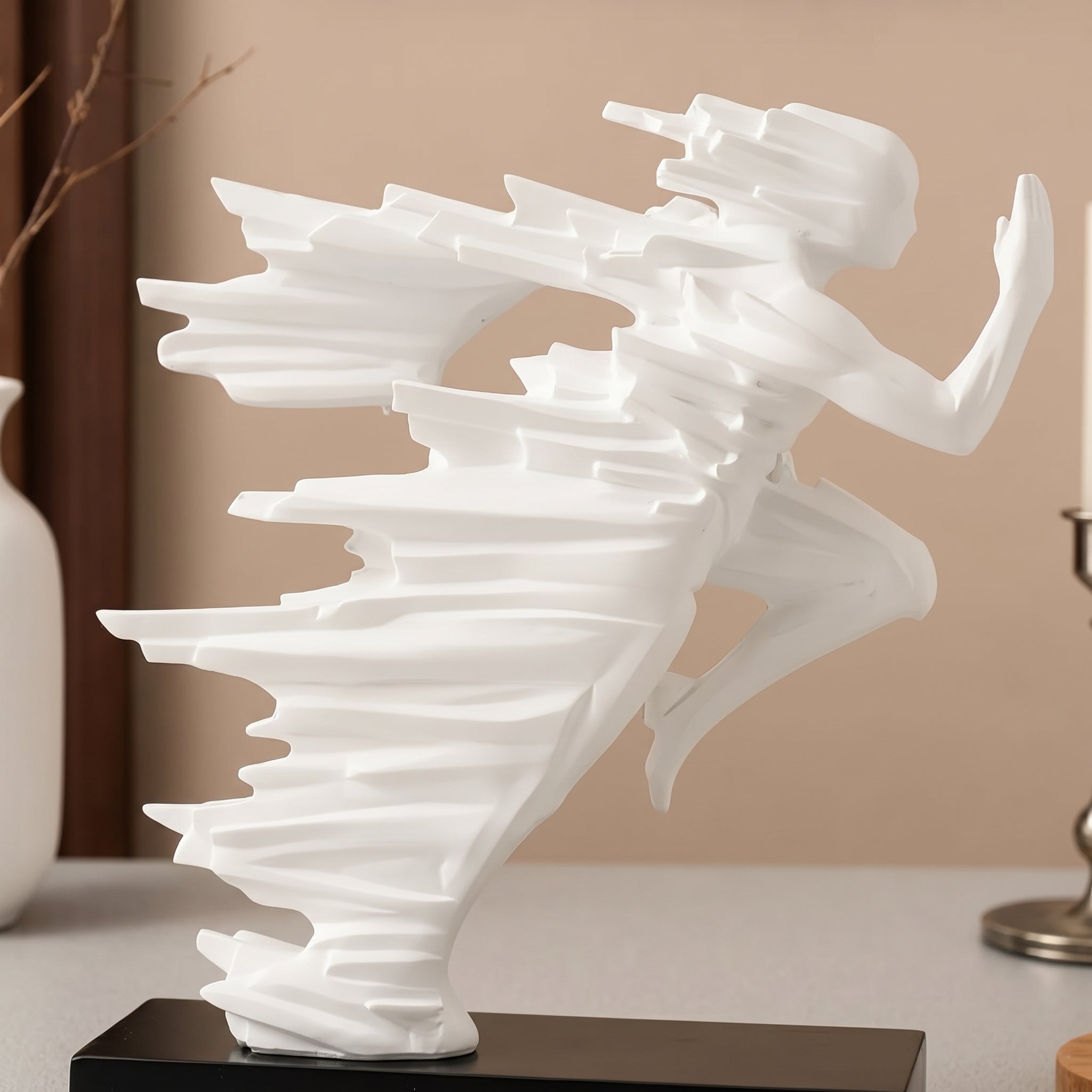 White abstract sculpture on a black base against a beige wall