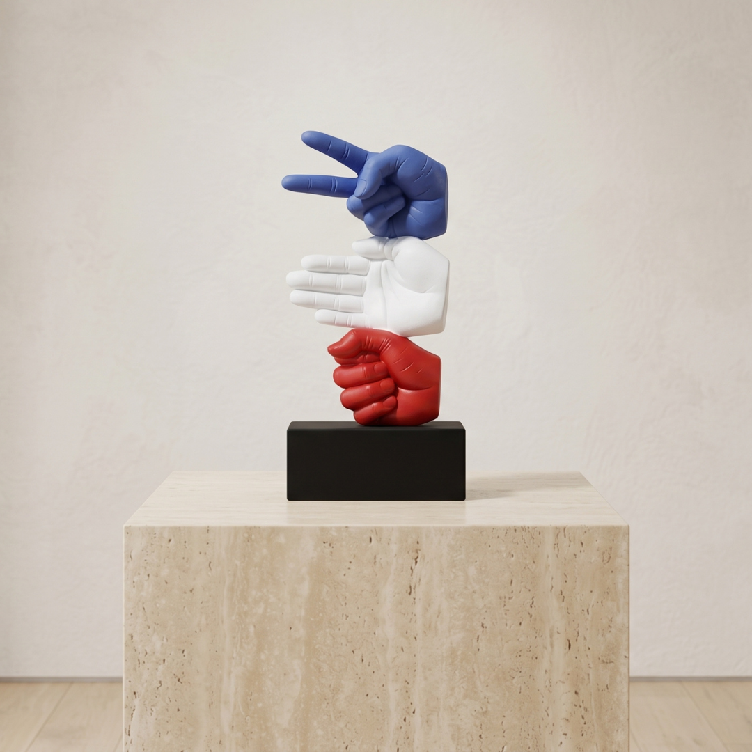 Colorful sculpture of three interlocking hands on a pedestal against a plain background