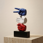 Three colorful gloves (blue, white, red) stacked on a black block against a beige background