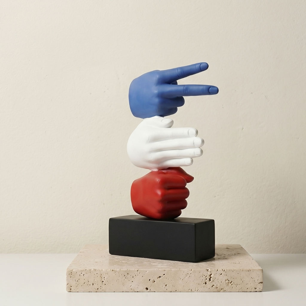 Colorful sculpture of three hands on a black block with a beige background